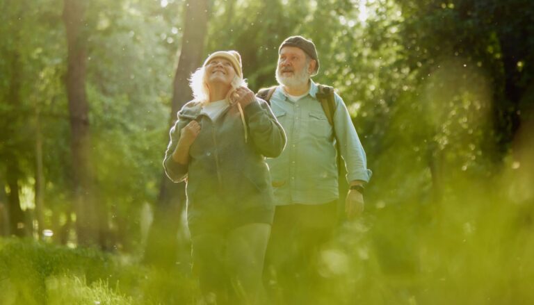 Senior couple, man and woman taking peaceful walk in park