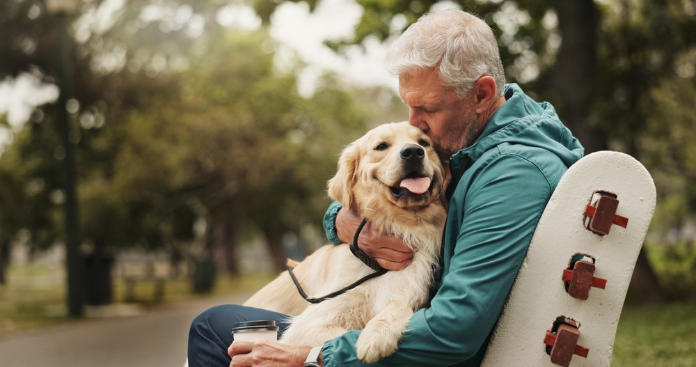 Park, senior man and dog with kiss for bonding